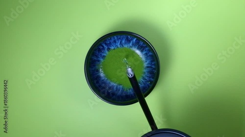 Leuchtend blaue Schüssel mit grünem Matcha-Pulver und heißem Wasser