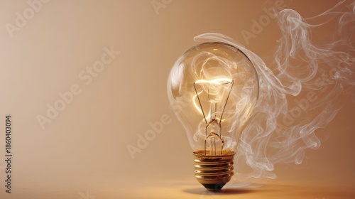 A glowing incandescent light bulb emits warm golden light with a clearly visible filament,