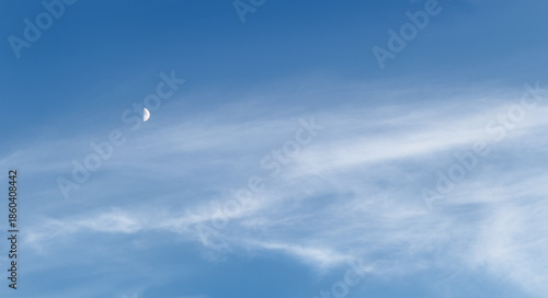 Blue sky background, moon light in white clouds, bright stars shining behind