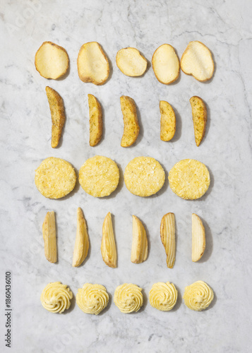 Assortment of frozen potatoes including skin-on wedges, potato wedges, and hash browns, displayed as a food background concept highlighting variety, convenience, and ready-to-cook products.