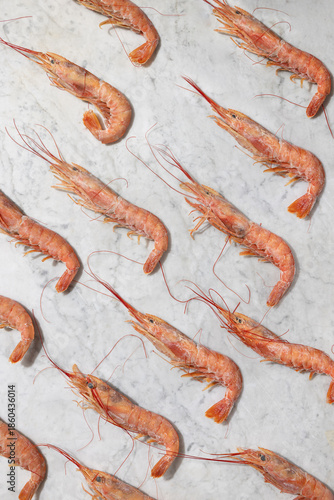 Frozen pink shrimp Parapenaeus longirostris displayed on a marble background, showcasing raw seafood quality, freshness, and commercial food concept