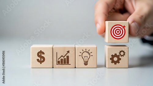 Hand placing a cube with a target icon on top of other blocks representing finance growth ideas and mechanisms high quality