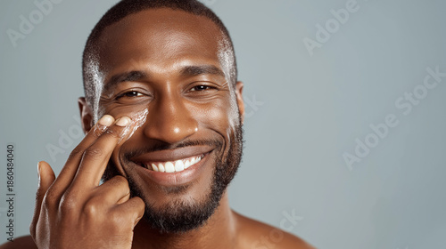 Smiling African American Man Applying Face Cream Under Eye, Skincare Routine, Moisturizing Treatment, Healthy Glowing Skin, Male Self Care Concept