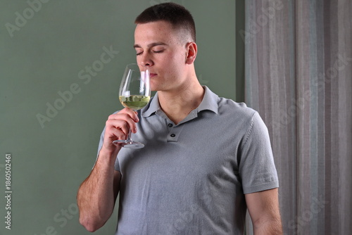 white male smelling his glass of white wine