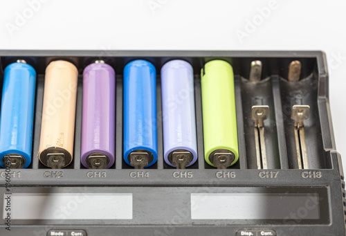 Close-up of a black battery charger with several colorful rechargeable batteries inserted in channels 1 through 6