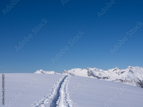 Praettigau, Switzerland - February 15th 2025: View along a snowshoe trail leading through an alpine winter landscape