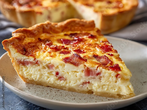 Delicious savory slice of bacon and cheese quiche on a plate high resolution image