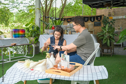 A heartwarming lifestyle series of a middle-aged Asian couple enjoying a relaxing home spa session. The man is seen lovingly caring for his wife by giving her a hand and foot massage