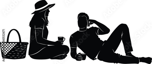Silhouette of two people relaxing on the ground with a basket