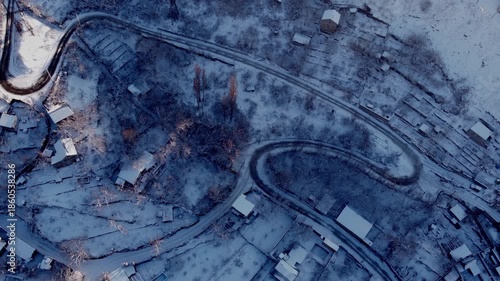 Still aerial video over a winding road in the countryside during a snowy winter