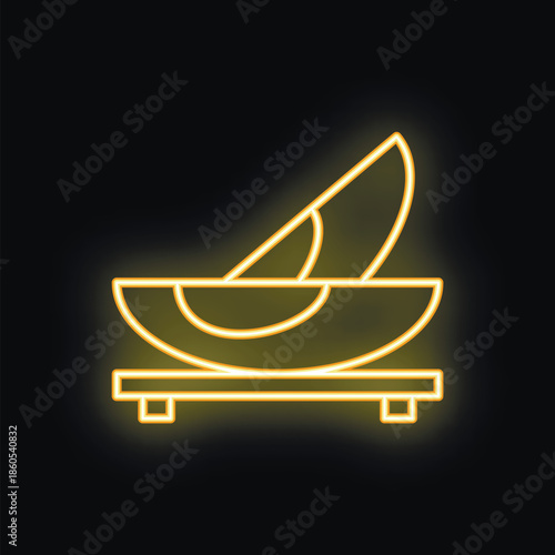 Neon sign depicting sliced avocado in bowl, glowing yellow against a dark background, evoking healthy eating and trendy visuals