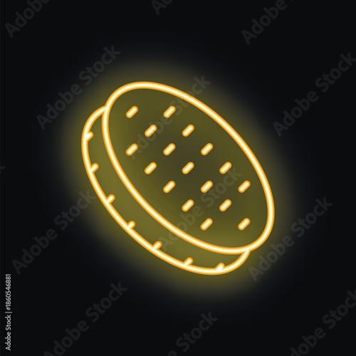 Yellow neon sign of a round cracker biscuit is glowing on black background
