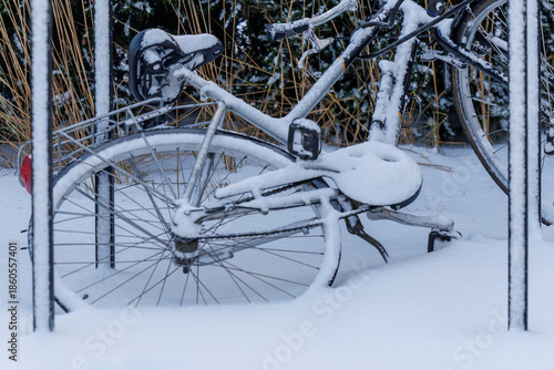 Bicycle covered with snow parked outdoors in winter