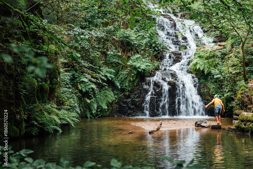 Konstfotografi un enfant jouant vers une cascade d'eau