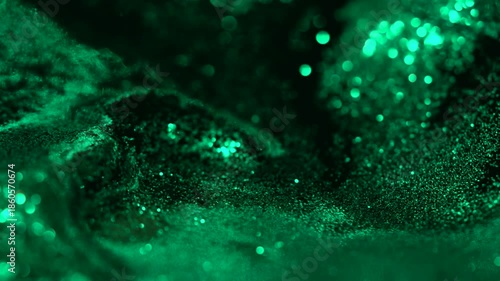 Green liquid abstract shimmering glitter particles moving across a dark macro surface, forming a smooth cinematic texture ideal for backgrounds, overlays, luxury visuals and design elements.