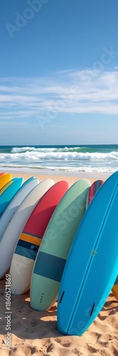 A vibrant row of surfboards awaits exciting spring break waves on a sunny sandy beach,  clear weather,  blue sky