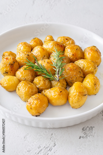 Oven baked baby potatoes seasoned with herbs served in white ceramic bowl