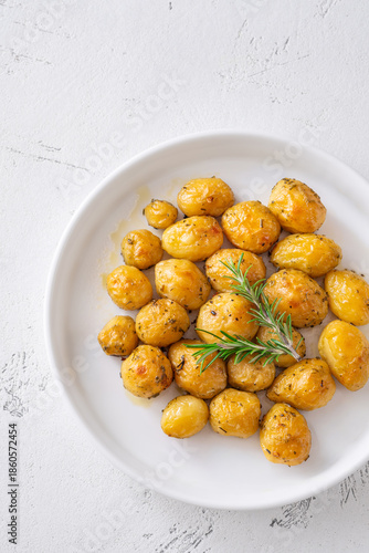 Oven baked baby potatoes seasoned with herbs served in white ceramic bowl