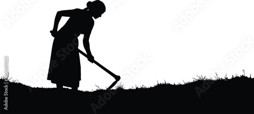 A silhouette of a woman working in a field with a hoe