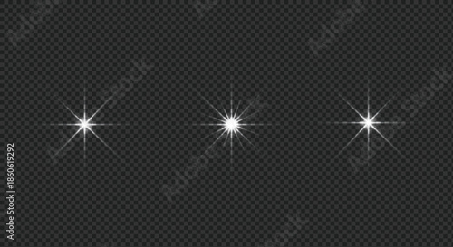 Set of three sparkling white light effects with radiating flares on a dark transparent background
