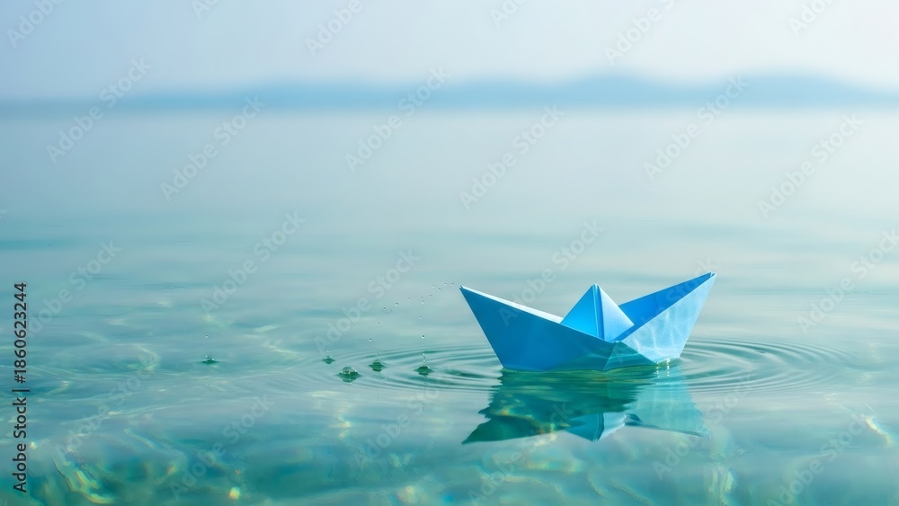 Obraz premium Paper Boat Dreams Blue Origami Voyage on Tranquil Turquoise Waters.