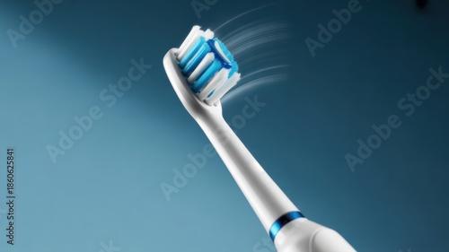 Close up of electric toothbrush head with blue and white bristles on blue background image
