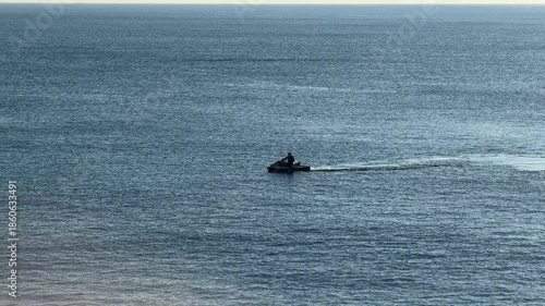 Jet ski riding across the Mediterranean sea with wide open water, dynamic travel video showing freedom and motion, personal watercraft on blue ocean with copy space and minimal composition