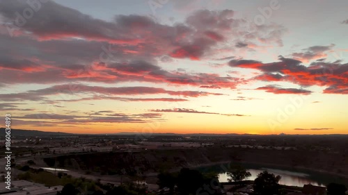 Aerial footage of a lake surrounded by homes and lush green trees at sunset in Duarte California USA