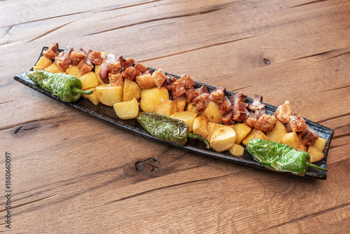 A modern presentation of pork belly on roasted apple purée, seeking a contrast between the saltiness and crispiness of the pork and the sweetness of the fruit