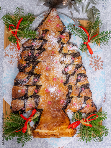 Christmas Tree Shaped Pastry Cake With Chocolate Swirls, Powdered Sugar, And Red Berries