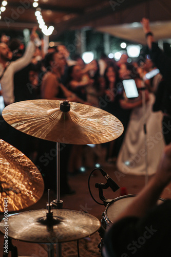 Detalle de un batería tocando la batería durante un concierto en directo, con enfoque en los platillos y la energía del escenario. Concepto de música en vivo y espectáculo.