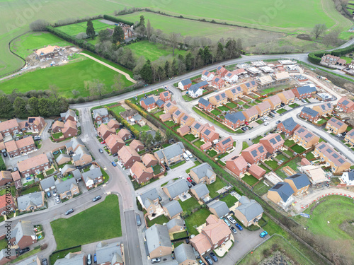 Interesting drone UAV view of a new housing estate with just a few homes left to complete. A manor house can be seen in the distance. Seen in Cambridgeshire, UK.