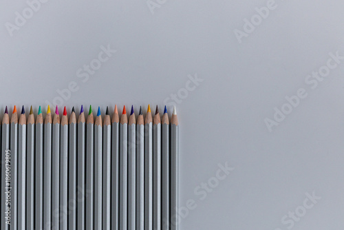 Pencils laid out in a row on a gray background