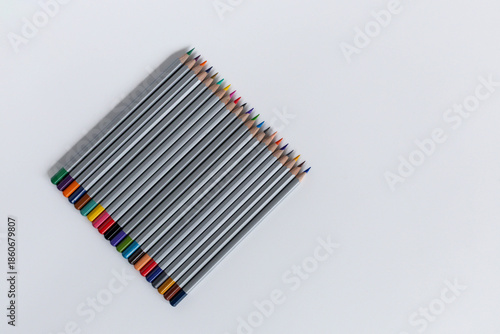 Pencils laid out in a row on a gray background
