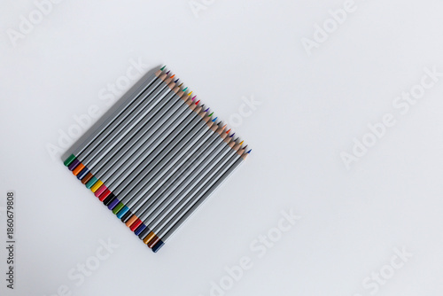 Pencils laid out in a row on a gray background