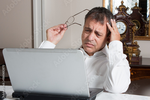 Stressed Middle-Aged Man Working on Laptop at Home Office