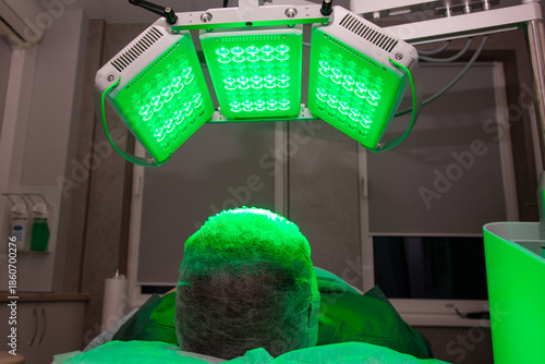 Young woman having LED light facial treatment in beauty salon