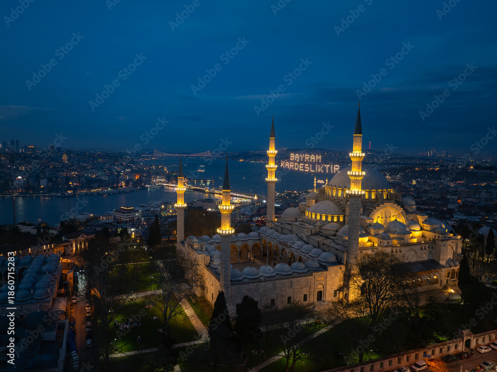Naklejka premium Illuminated Letters Between Minarets (Mahya), Ramadan Background in the Istanbul Streets, Welcome Ramadan Month Text, Ramadan Kareem Drone Photo, New Valide Mosque Uskudar, Istanbul Türkiye (Turkey)