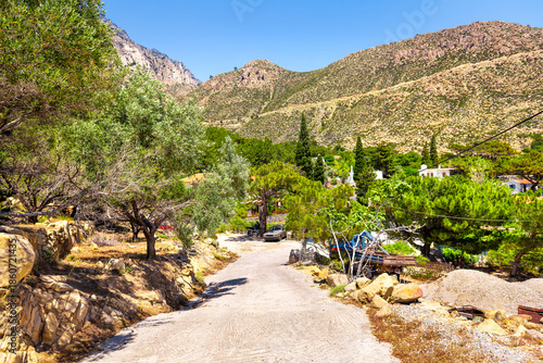 Karkinagri, Ikaria island Greece with Atheras mountain range cliffs in summer by small farm house home with olive tree garden in North Aegean