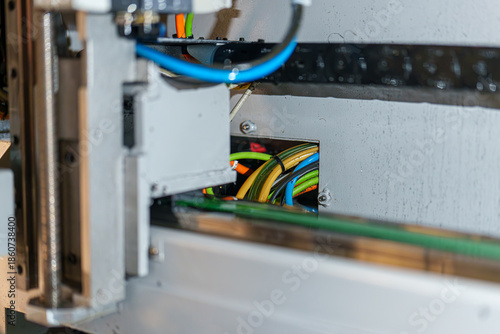 Details of a machine showing wires and components in an industrial setting during daylight hours