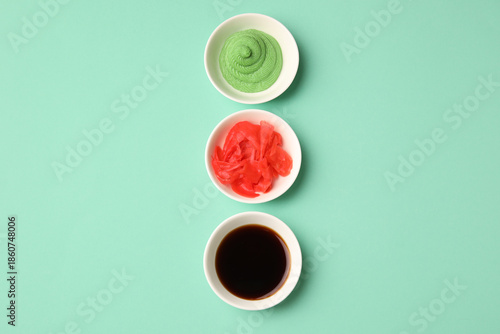 Bowls with wasabi, soy sauce and pickled ginger on turquoise background © Pixel-Shot