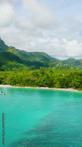 Wallpaper Mural Coastal bay surrounded by lush mountains and clear turquoise sea water with boats. Seychelles, Mahe. Launay Beach. Torontodigital.ca