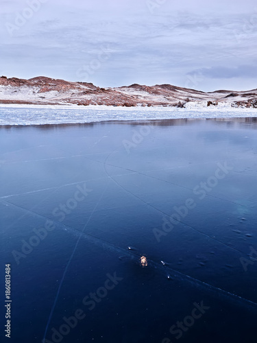 Baikal Lake in winter. Beautiful landscape with mountains reflected in ice of frozen Small Sea