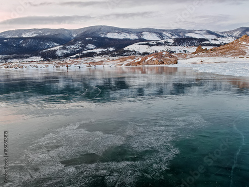 Baikal Lake in winter. Beautiful landscape with mountains reflected in ice of frozen Small Sea