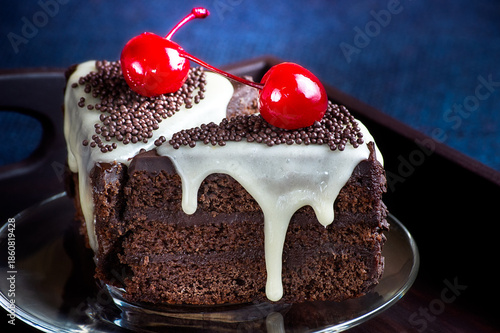 Chocolate cake with dripping glaze and canned cherry.
