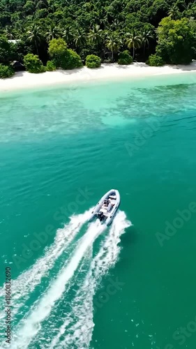 An aerial view showcases a speedboat cruising turquoise waters near a tropical island shore