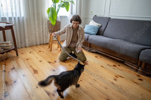 Canvas-taulu Woman pet caretaker playing with cat on floor at home