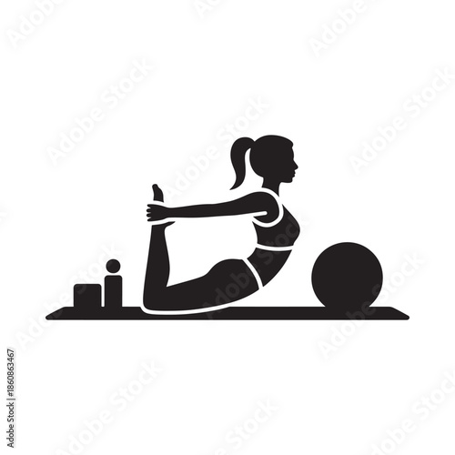 Silhouette of a woman practicing yoga with a ball and blocks