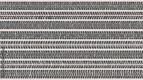 Close-up view of multiple parallel rows of tire tracks and tread patterns, showcasing various textures and designs on a light background.