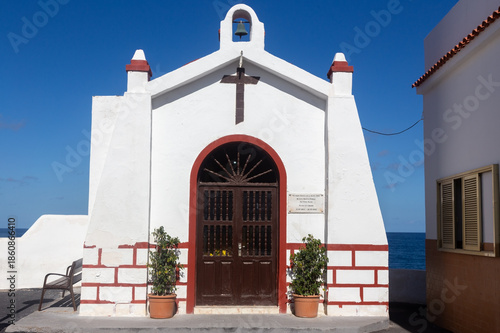Ermita de la Santa Cruz, a small beautiful heritage catholic chapel with white exterior facade on Puerto de la Cruz seaside cliffs, Tenerife Canary Islands Spain